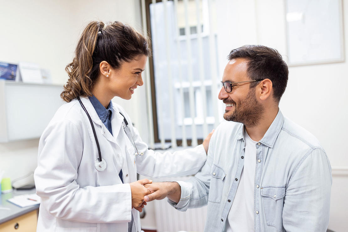 Young physician shaking hands with a smiling patient