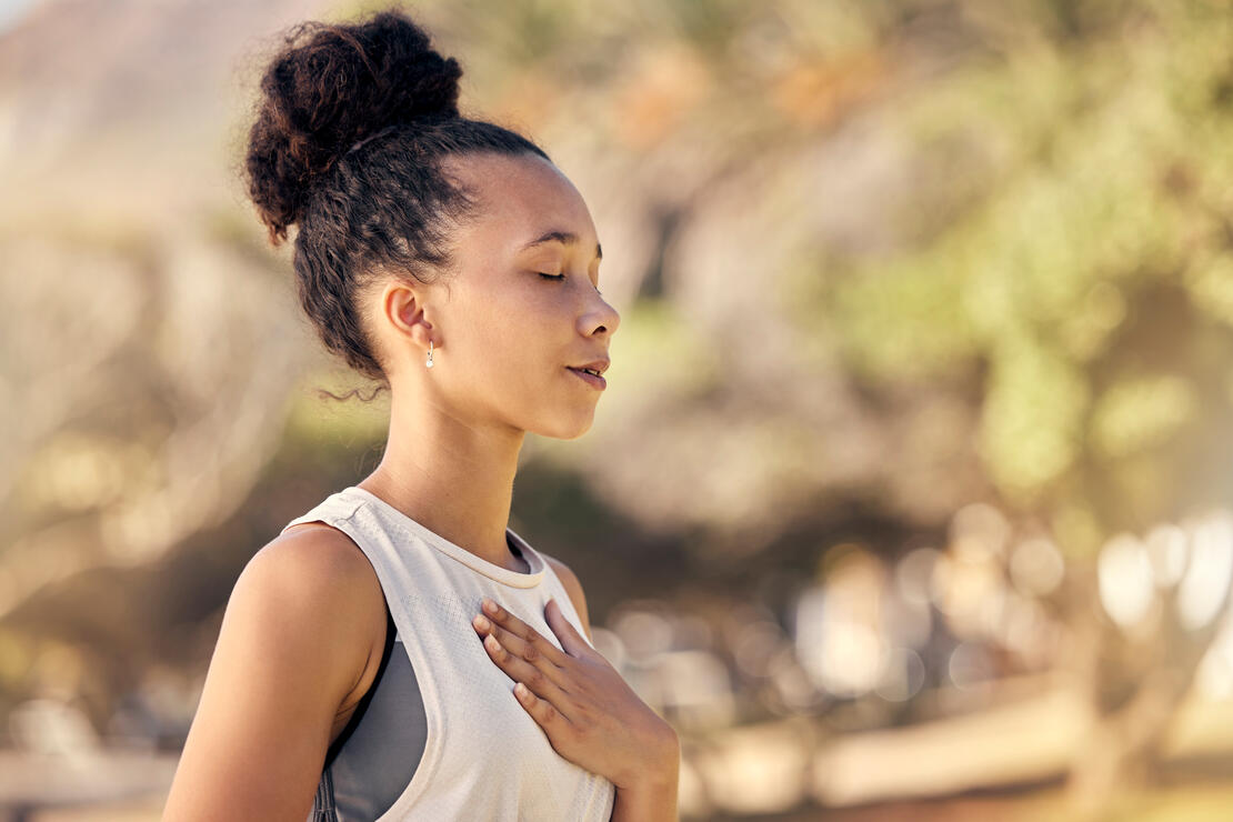 Young runner taking a break with hand on her chest