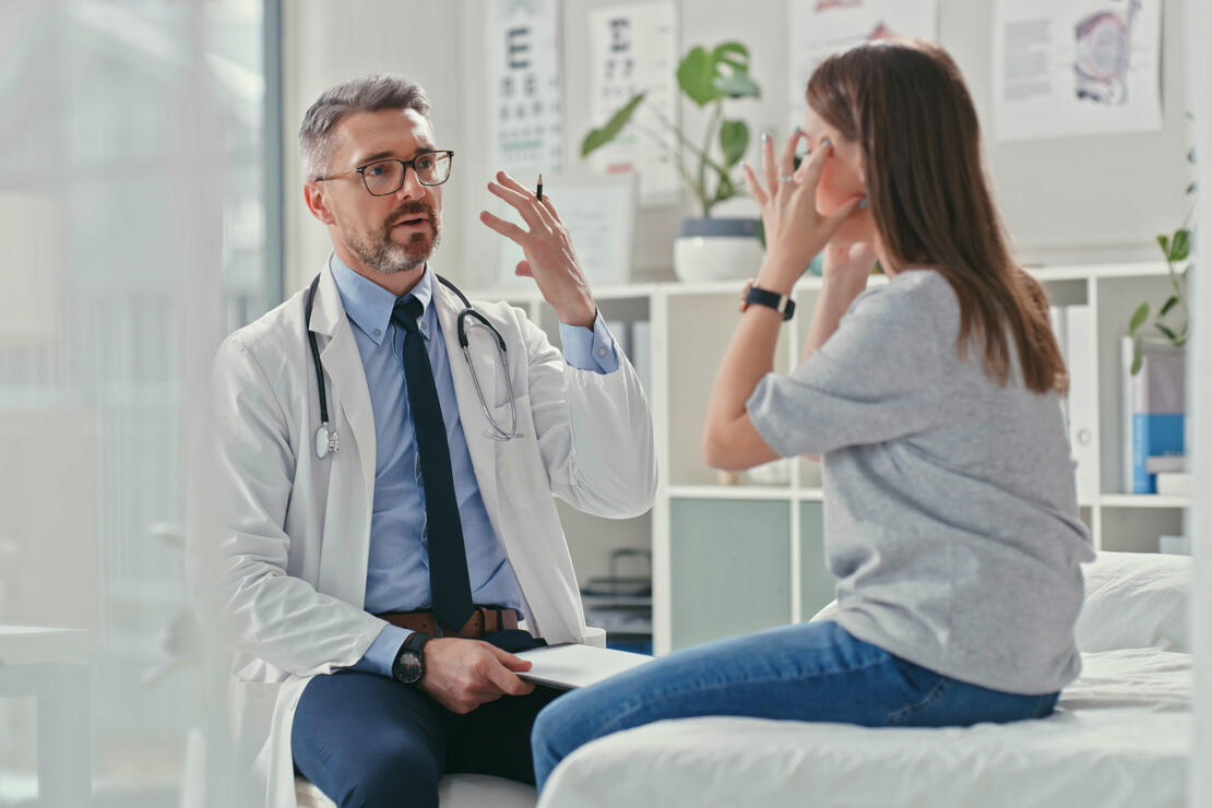 Shot of an older doctor sitting with his patient in the clinic and asking questions during a consultation
