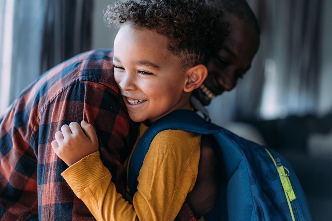 Shot of young father embracing his son while sending him to school.