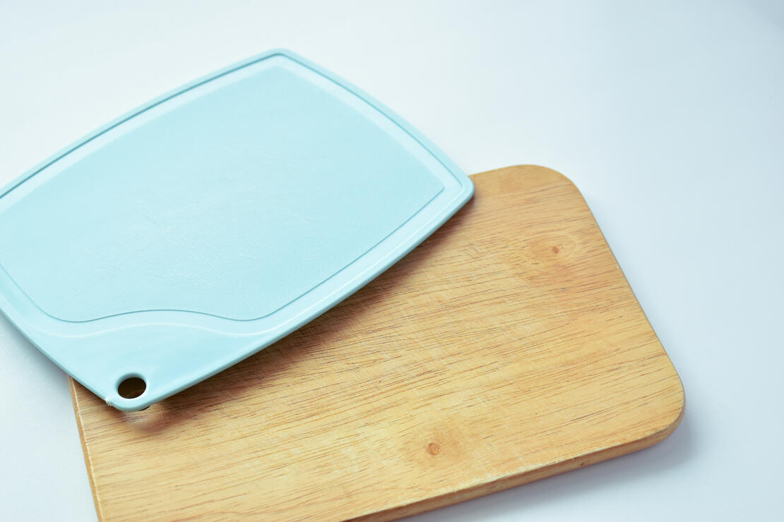 blue plastic and brown wooden cutting board isolated on white background, equipment for cooking in the kitchen