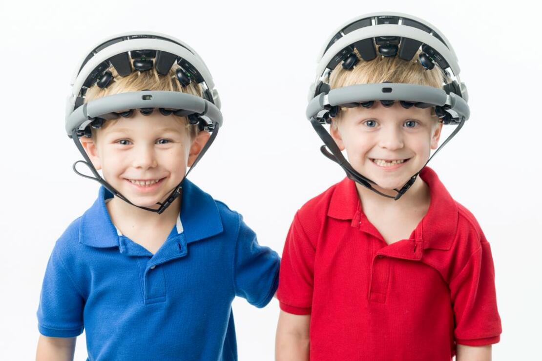Two young boys smiling while wearing Zeto headsets