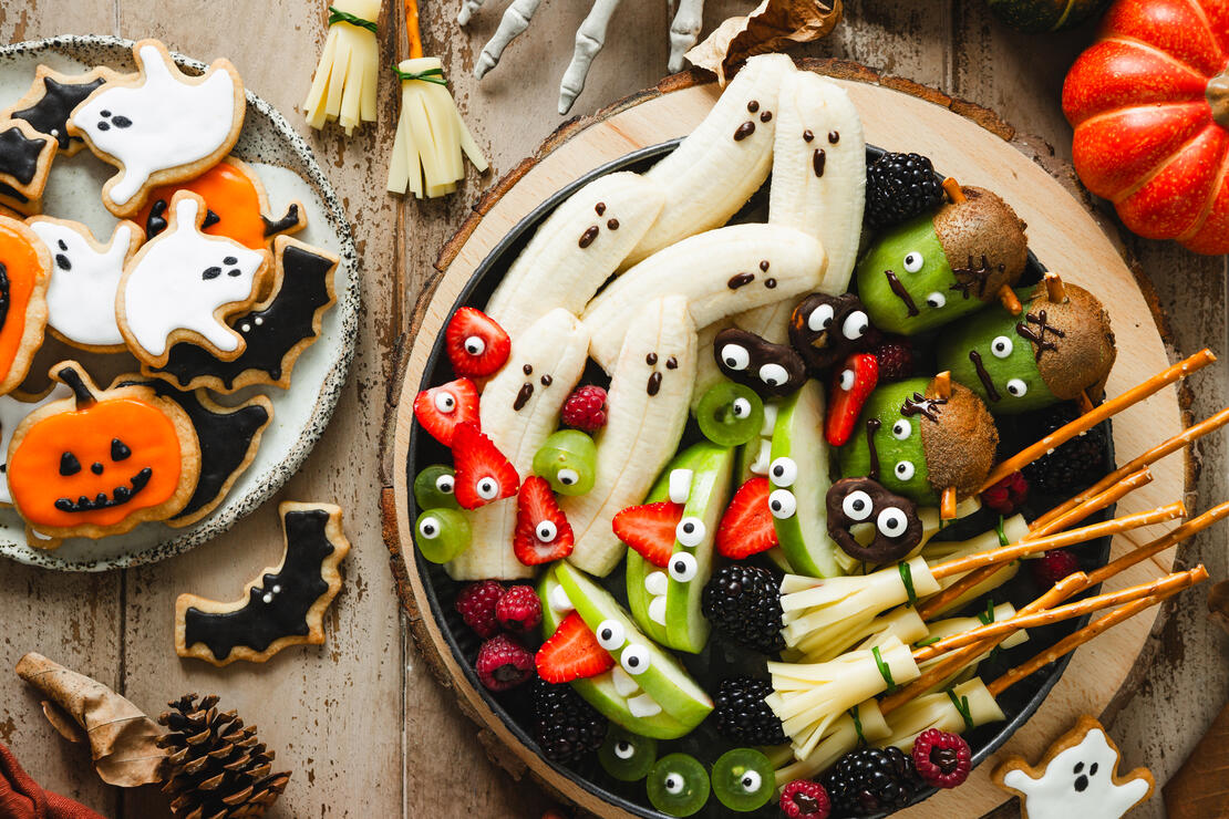 Top view of festive Halloween table setup with funny decorated fruit plate. Halloween table setup with creatively decorated plate of fruits for a fun and festive holiday celebration.
