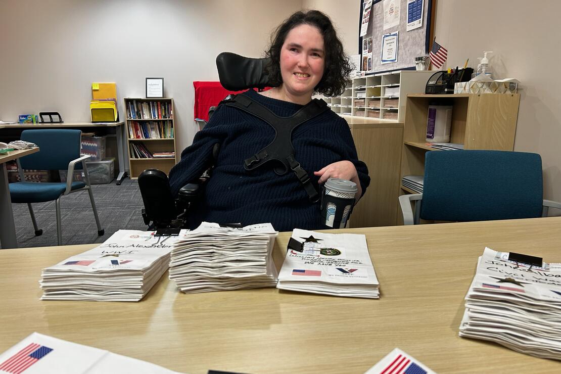 Taylor Chaffin, 28-year-old volunteer and BridgingLife patient, smiles after prepping luminary bags for Gold Star Family Day.