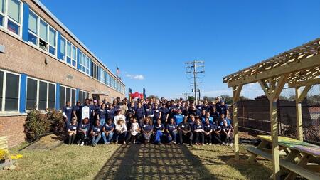 Wide angle photo of the volunteer group next to Mary Ann Winterling Elementary