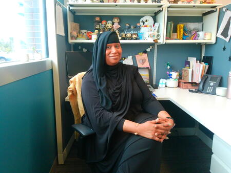 Image of Nicole, a forensic interviewer at Center for Hope, seated and smiling at her desk. 