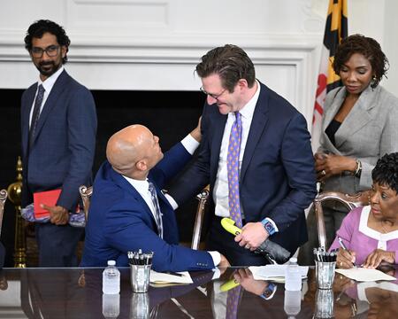 Maryland Governor Wes Moore shaking hands with Vice President of Violence Intervention and Prevention of LifeBridge Health Adam Rosenberg after signing SB 443.