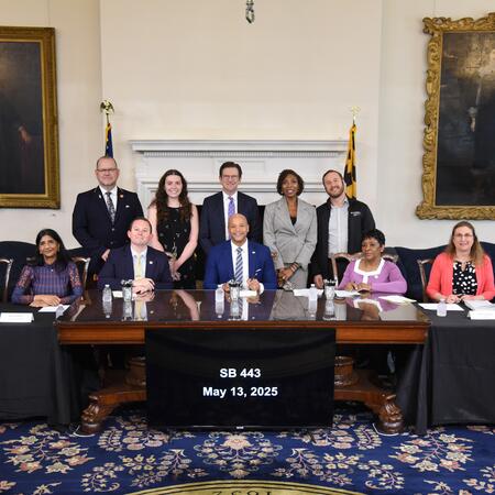 Maryland Governor Wes Moore, Vice President of Violence Intervention and Prevention Adam Rosenberg and supporters after signing SB 443.