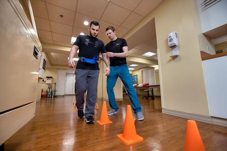 Physical therapist guiding a patient around cones at the Rehabilitation Institute at Sinai
