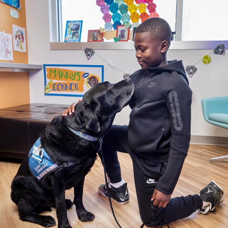 A boy petting a therapy dog