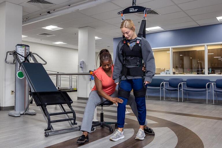 A therapist helping a patient relearn to walk