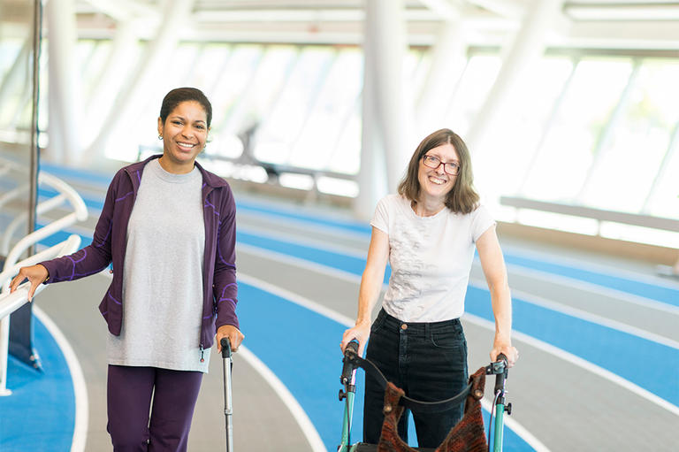Two people walking on an indoor track