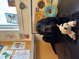 Manny, the four-legged companion at Center for Hope, sits in his corner with a lamb toy between his front paws.