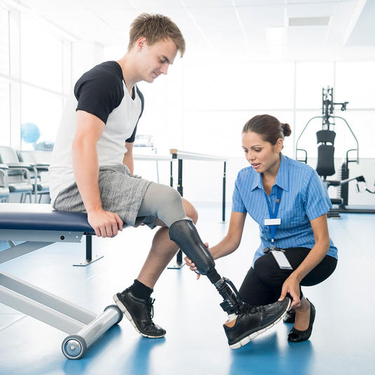 A physician working with a prosthetic limb