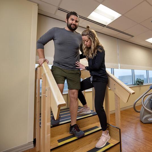 Patient learning to walk with a doctor in the hospital