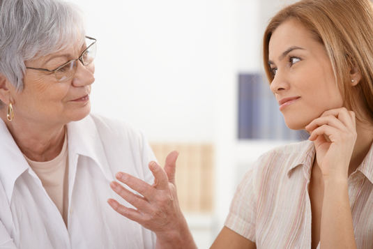 An elderly woman explaining something to another woman An elderly woman explaining something to another woman