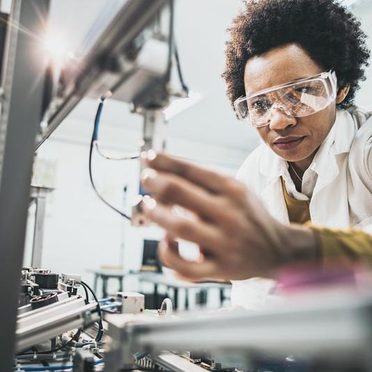 Image of a person working with a robotic device in a lab.
