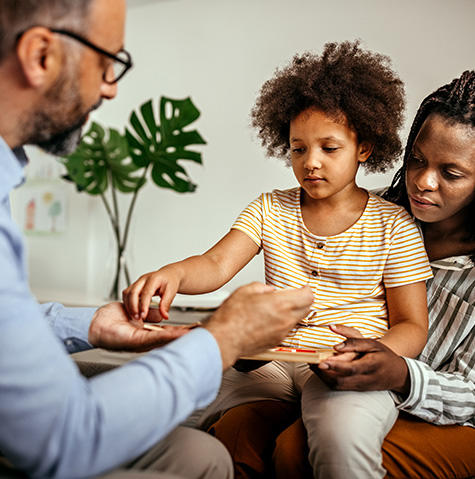 Pediatric patient and her mom in the child life area with a doctor