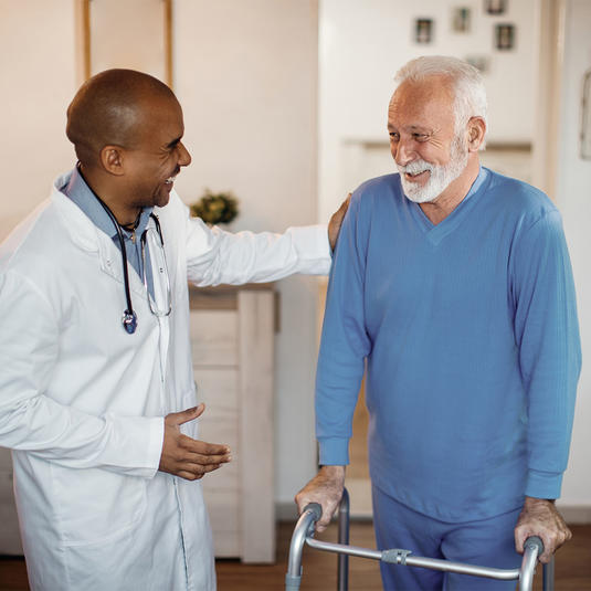 Doctor talking to a patient with a walker who is using the gait lab