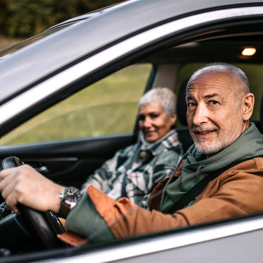 Senior couple of adventurers in car, going on a road trip