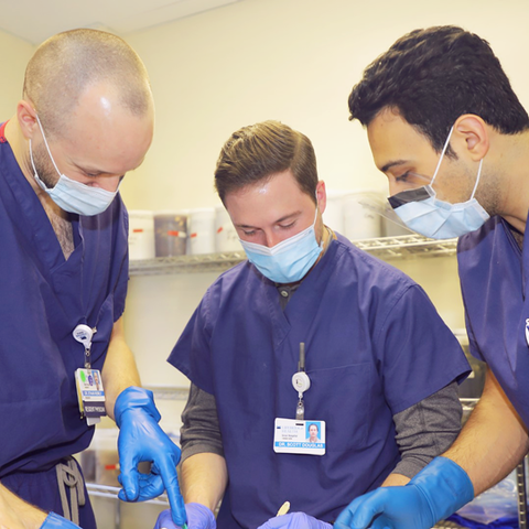 ADoctors consulting one another on a procedure